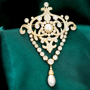 Détail macro d'une broche en perles vintage royale avec zircons sur velours vert foncé