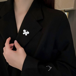 Elegant silver butterfly brooch with sparkling crystals pinned on a black suit lapel