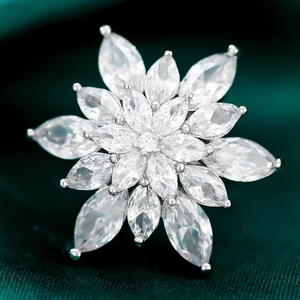 Exquisite silver snowflake brooch with marquise-cut cubic zirconia on green silk fabric