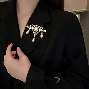 Elegant pearl and rhinestone brooch with teardrop tassels on black suit lapel