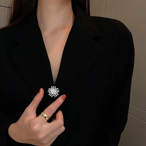 Détail d'une broche flocon de neige étincelante avec zircons sur une veste de costume noire