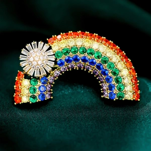 Macro shot of luxury rainbow brooch with colorful gemstones on dark green silk backdrop