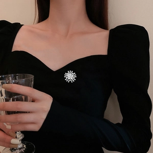 Broche flocon de neige exquise avec micro-zircons sur un chemisier noir élégant et chic