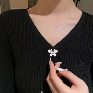 Elegant silver butterfly brooch with sparkling crystals pinned on a black knit cardigan