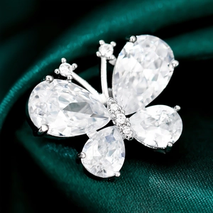 Macro detail of elegant silver butterfly brooch with pear-shaped white crystal gems