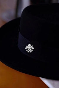 Gros plan d'une broche flocon argentée avec zircons brillants sur ruban de chapeau