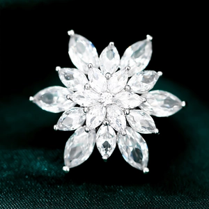 Elegant snowflake brooch with marquise-cut cubic zirconia on dark green velvet fabric