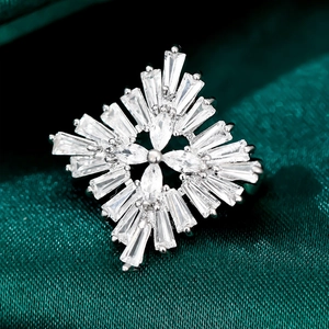 Detailed macro view of a silver snowflake brooch with marquise and baguette crystals