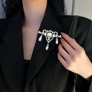 Macro view of crystal brooch with teardrop pearls pinned on a black suit lapel