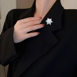 Macro detail of a sparkling snowflake brooch with zircons on a black suit lapel