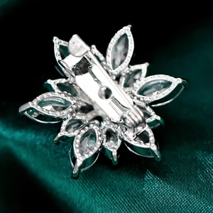 Macro detail of snowflake brooch back featuring silver alloy base and safety pin clasp