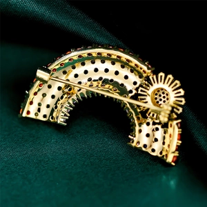 Macro shot of gold-plated brooch back with intricate cutouts and safety pin detail