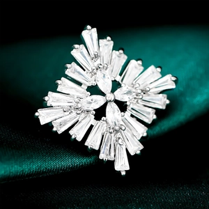 Micro-inlaid zircon snowflake brooch with silver metal finish on dark green satin fabric