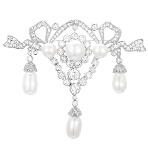 Detail of vintage silver brooch with cubic zirconia, lace patterns, and teardrop pearls