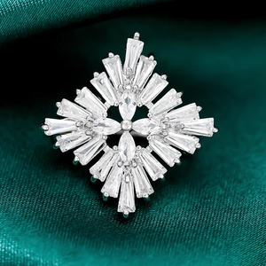 Macro shot of micro-pave zircon snowflake brooch on elegant dark green satin fabric