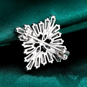 Detail view of the silver snowflake brooch back showing the secure safety pin buckle