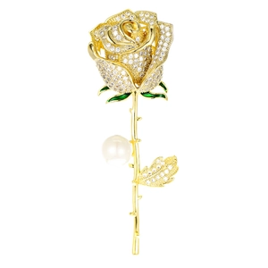 Elegant gold rose flower brooch with white crystal petals and a small pearl accent
