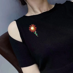 Elegant sunflower brooch with red crystals and white pearl on black knitwear