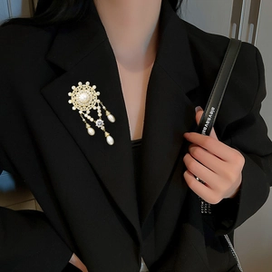 Detail of luxury freshwater pearl brooch with zircon tassels on a black blazer