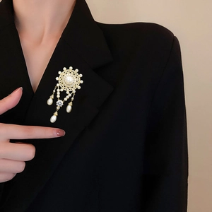 Elegant gold-plated freshwater pearl brooch with zircon crystals on black blazer
