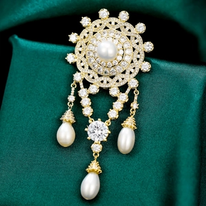 Detailed macro view of vintage gold brooch with freshwater pearls and zircon accents
