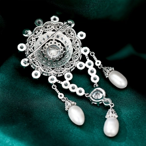 Macro view of the secure metal pin back on a vintage-style pearl and zircon brooch