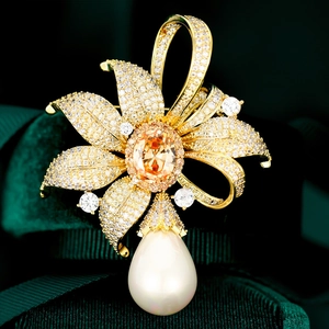 Détail macro d'une broche florale de luxe avec pierre orange et perle en goutte