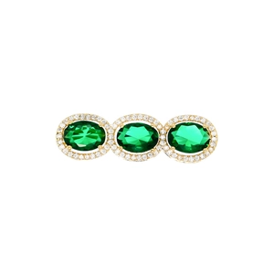 Detailed macro view of triple green oval gemstones with zircon halo in golden pin setting