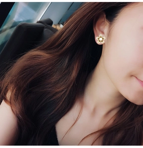 Vue détaillée d'une boucle d'oreille fleur à cinq pétales avec perle sur mannequin