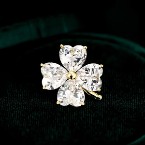 Elegant four-leaf clover brooch with heart-cut zircons and gold-plated base on green velvet