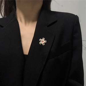 Vue détaillée d'une broche cerisier en fleur avec zircon sur un revers de veste