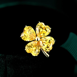 Macro shot of yellow heart-shaped gems on a four-leaf clover brooch with gold finish