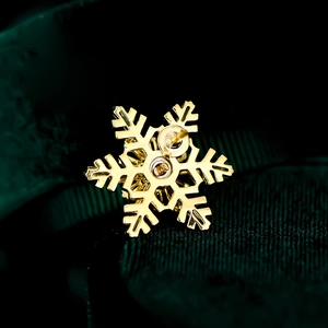 Detailed macro view showing the golden snowflake earring back and butterfly clasp