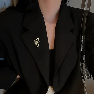 Detail of hollow butterfly brooch with white rhinestones on a black suit jacket