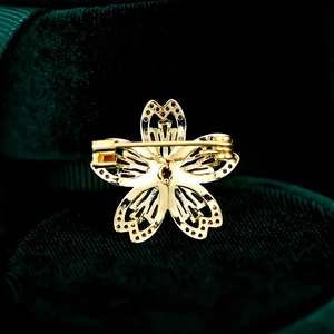 Vue macro du dos de la broche fleur dorée avec découpes en cœur et épingle de sûreté