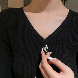 Elegant gold hollow butterfly brooch on black sweater with sparkling crystal accents