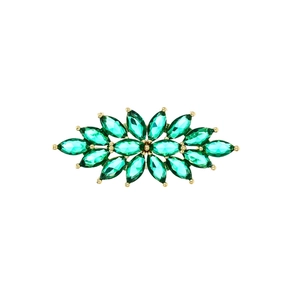 Detail einer eleganten Blumenbrosche mit grünen Kristallen in goldener Fassung