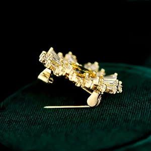 Détail de la broche fleur dorée avec pierre jaune et accents de zircons brillants