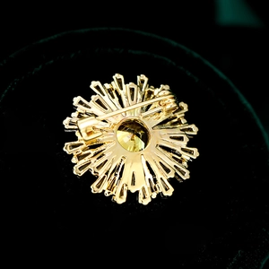 Vue détaillée du dos de la broche fleur dorée avec épingle de sûreté et texture ciselée
