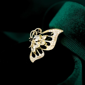 Detailed macro view of the gold butterfly brooch with white zircon and black gemstone accents