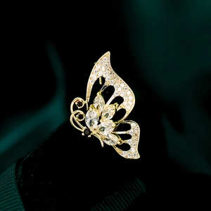 Macro view of gold butterfly brooch with marquise zircons and pavé diamonds