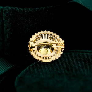 Makroaufnahme der goldenen Brosche mit gelbem Edelstein und sicherem Ansteckverschluss