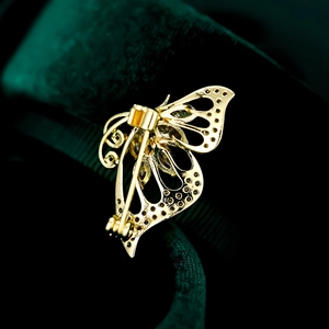 Macro view showing the back pin structure and gold-plated metal finish of butterfly brooch