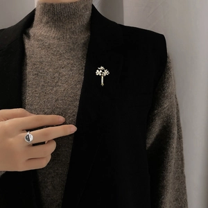 Vue détaillée d'une broche bouquet de fleurs dorée avec cristaux sur revers noir