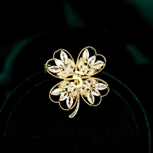 Elegant gold four-leaf clover brooch with white crystals and number 5 on velvet box