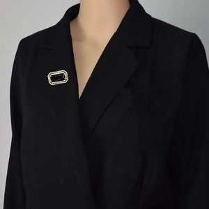 Spilla vintage rettangolare con zircone viola e accenti dorati su un blazer