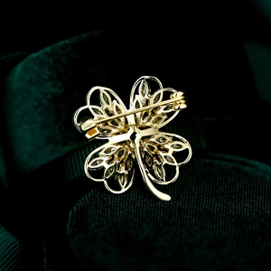 Close-up of the secure safety pin clasp on the gold clover brooch reverse side