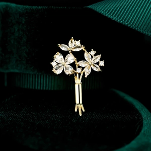 Détail macro de la broche bouquet avec oxydes de zirconium et finition dorée