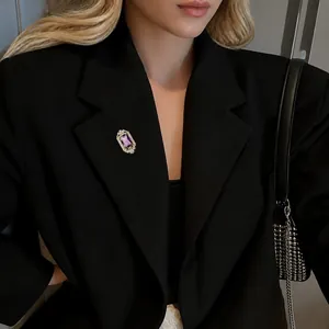Detail einer Vintage-Brosche mit lila Stein am schwarzen Revers eines eleganten Anzugs
