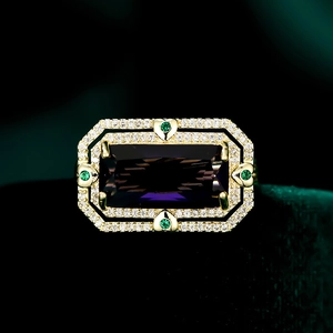 Dettaglio anello in oro con gemma viola taglio smeraldo e cuori verdi decorativi